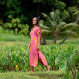 woman wearing a pink v neck maxi dress with lei print