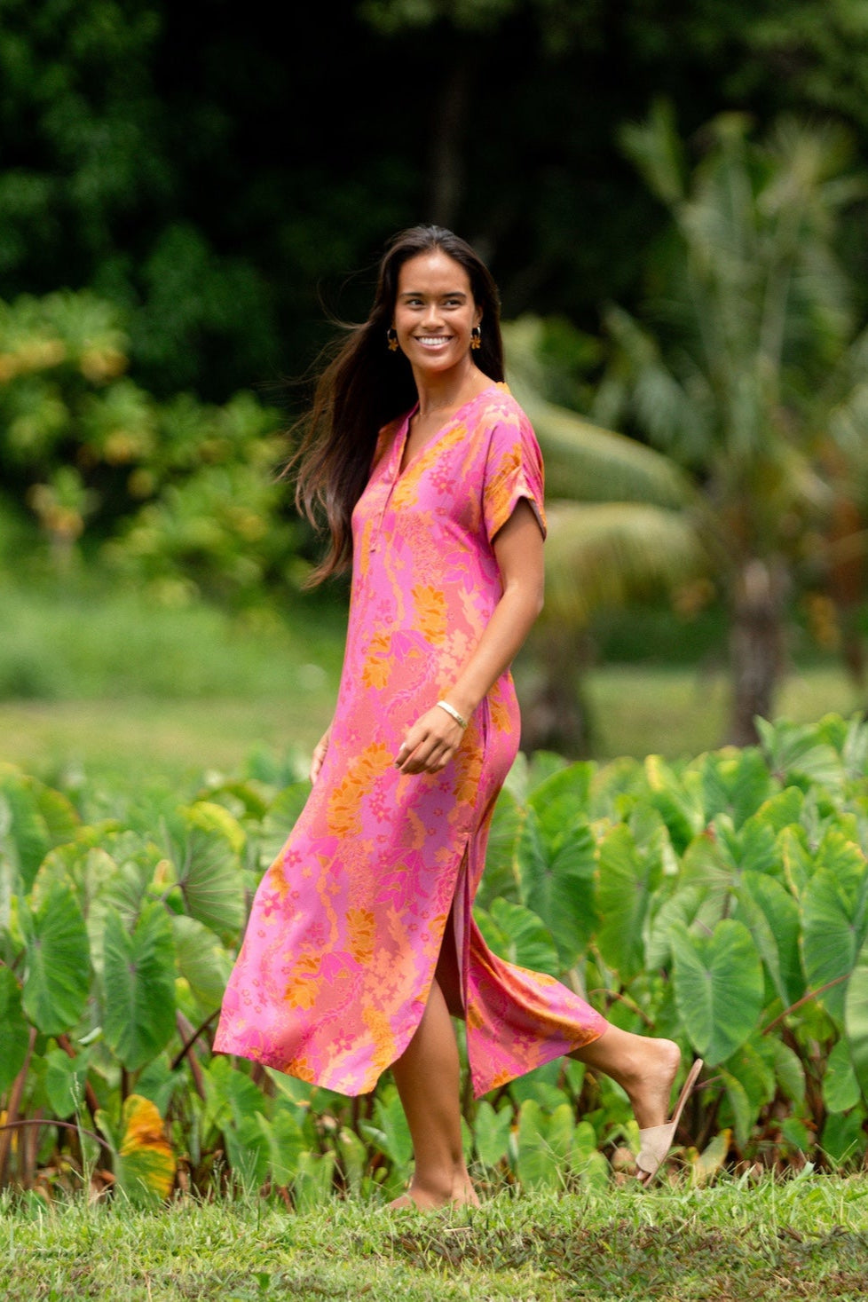 woman wearing a pink v neck maxi dress with lei print