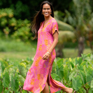 woman wearing a pink v neck maxi dress with lei print