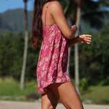 woman with brown hair wearing saghetti strap romper with shell and pua print in a pink color