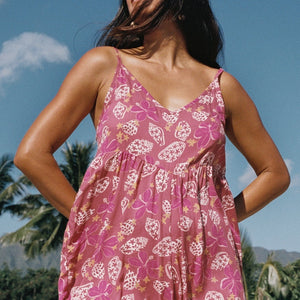 woman with brown hair wearing spaghetti strap romper with shell and pua print in a pink color