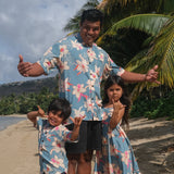 man wearing a teal aloha button up shirt with cream colored orchid pattern