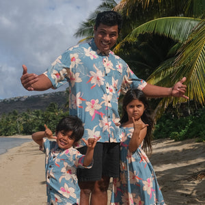 man wearing a teal aloha button up shirt with cream colored orchid pattern