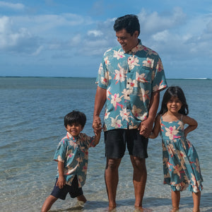 man wearing a teal aloha button up shirt with cream colored orchid pattern