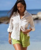 The YIREH A La Mode Button-Up in Cloud is a linen, slightly oversized, long-sleeve button-up featuring mother-of-pearl shell buttons.  - w/ Parakeet Millie Short