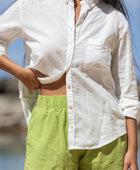 The YIREH A La Mode Button-Up in Cloud is a linen, slightly oversized, long-sleeve button-up featuring mother-of-pearl shell buttons. - w/ Parakeet Millie Short & Rumi Bandeau