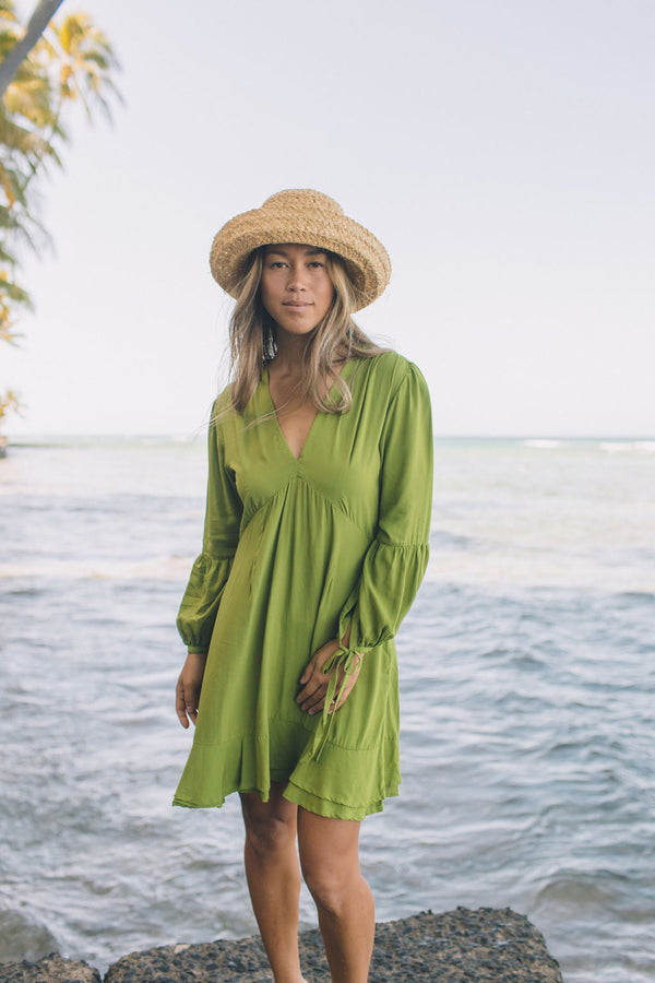 The Yireh Aster Dress in basil. Romantic and feminine silhouette. This is a classic Yireh style featuring flowing sleeves with a tie at the wrist and a zipper closure in back. Part of our limited run of solids, perfect to transition from day to night. Ethically and sustainably made resort wear.