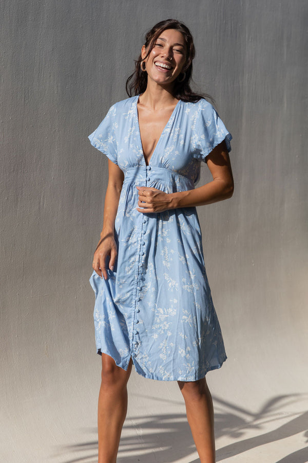 The Yireh Brynn Dress in Sky. A very flattering and versatile dress featuring covered buttons down the front and a tie back. Ethically and sustainably made with exclusive one of a kind prints.
