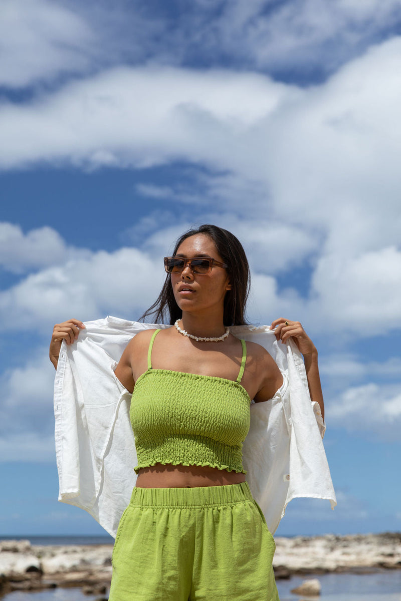 The YIREH A La Mode Button-Up in Cloud is a linen, slightly oversized, long-sleeve button-up featuring mother-of-pearl shell buttons.  - w/ Parakeet Millie Short & Rumi Bandeau